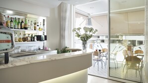 Un vestíbulo de hotel moderno con una zona de bar, asientos y vistas al exterior.