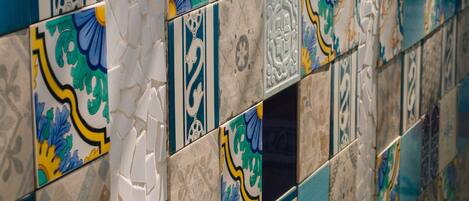 Paredes com mosaico de azulejos com padrões geométricos e florais.