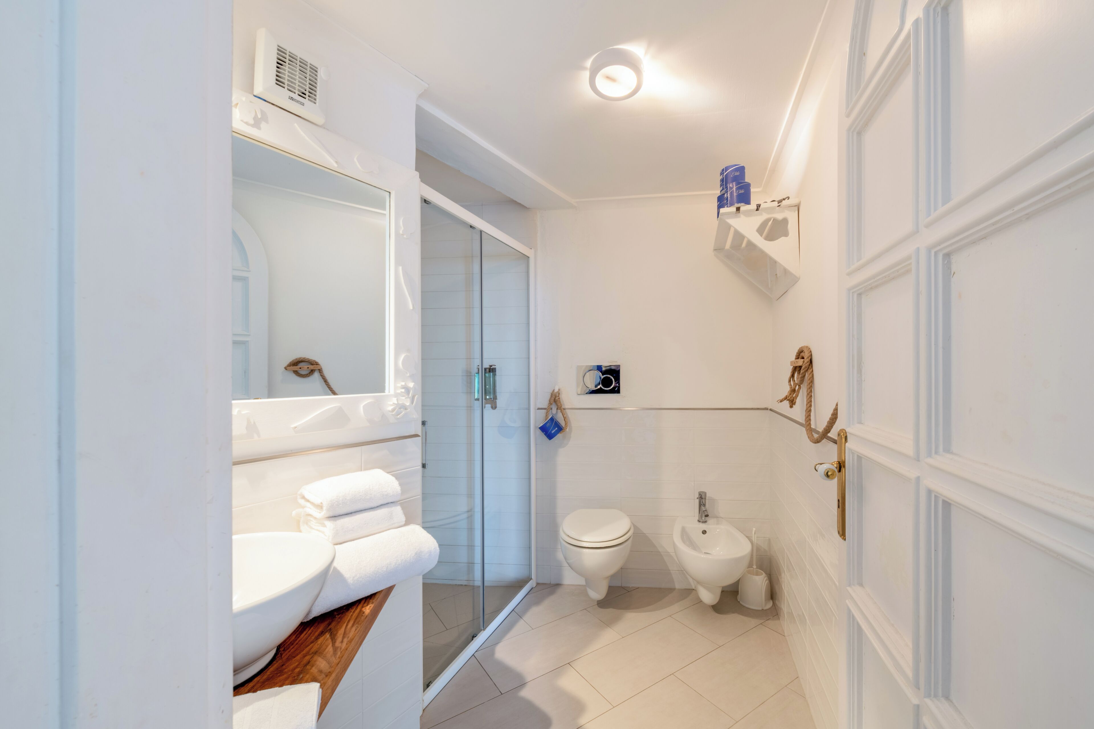 A bathroom with a toilet, bidet, and a glass shower enclosure.