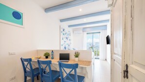 A dining area with a wooden table, blue chairs, and a laptop. - Le Terrazze (Sorrento)