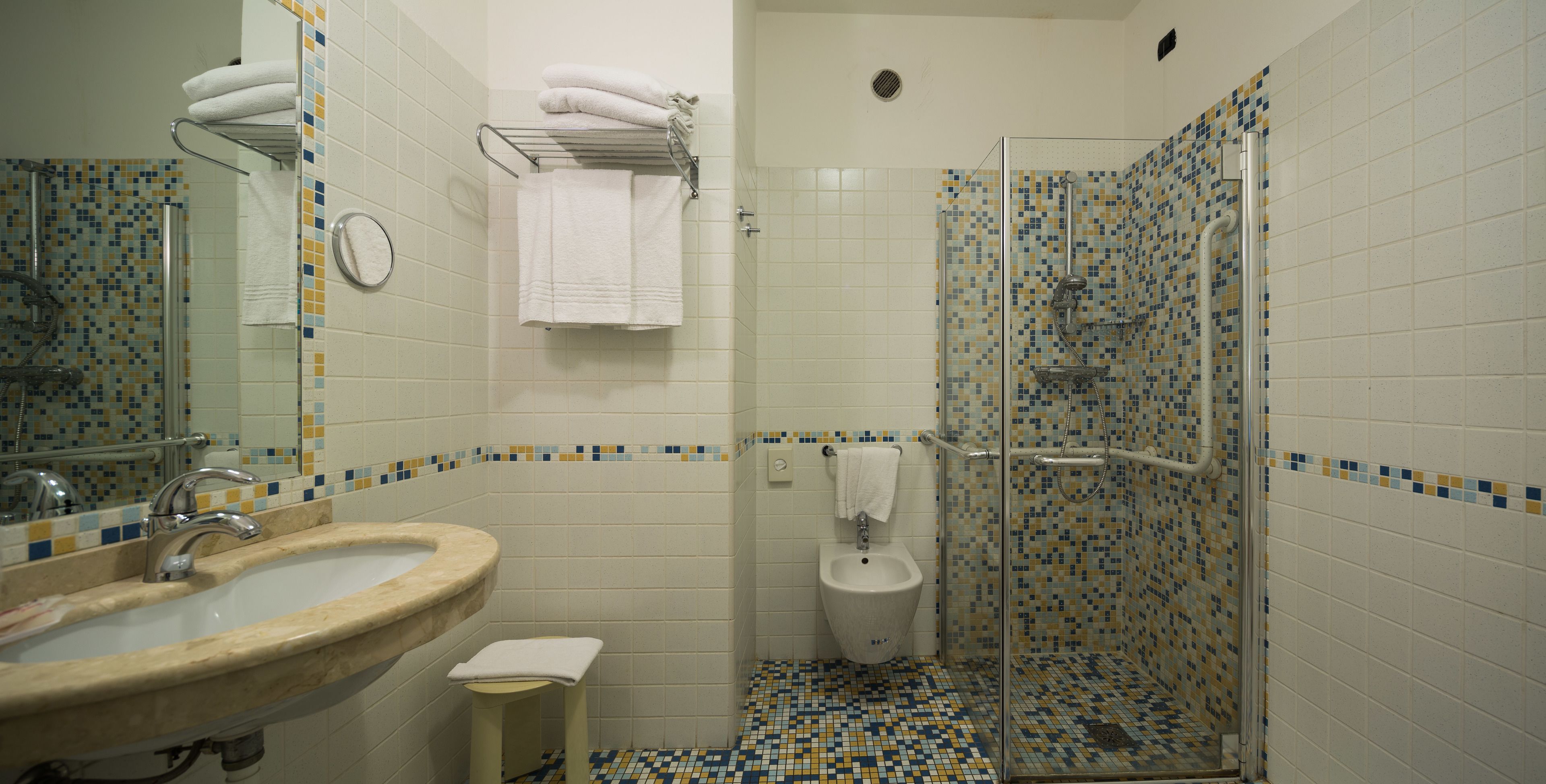 A bathroom with a sink, toilet, and glass shower enclosure.
