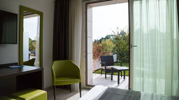 Une chambre d’hôtel comprenant un lit, un bureau, une chaise et un balcon avec une table et des chaises.