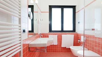 Un baño con un ventanal amplio, un lavabo blanco, una bañera y un inodoro.