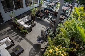 An outdoor patio area with seating arrangements, tables, and potted plants. - Hotel Ladurner (Merano)