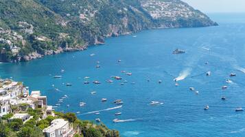 A coastal town with boats on the water and buildings on the hillside.