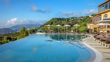 Alberca al aire libre, sombrillas en la alberca y camastros