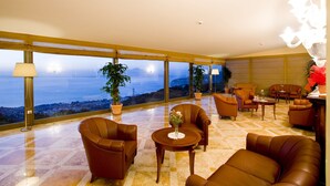 Un vaste balcon offrant une vue sur la mer, aménagé avec des canapés en cuir et une petite table.