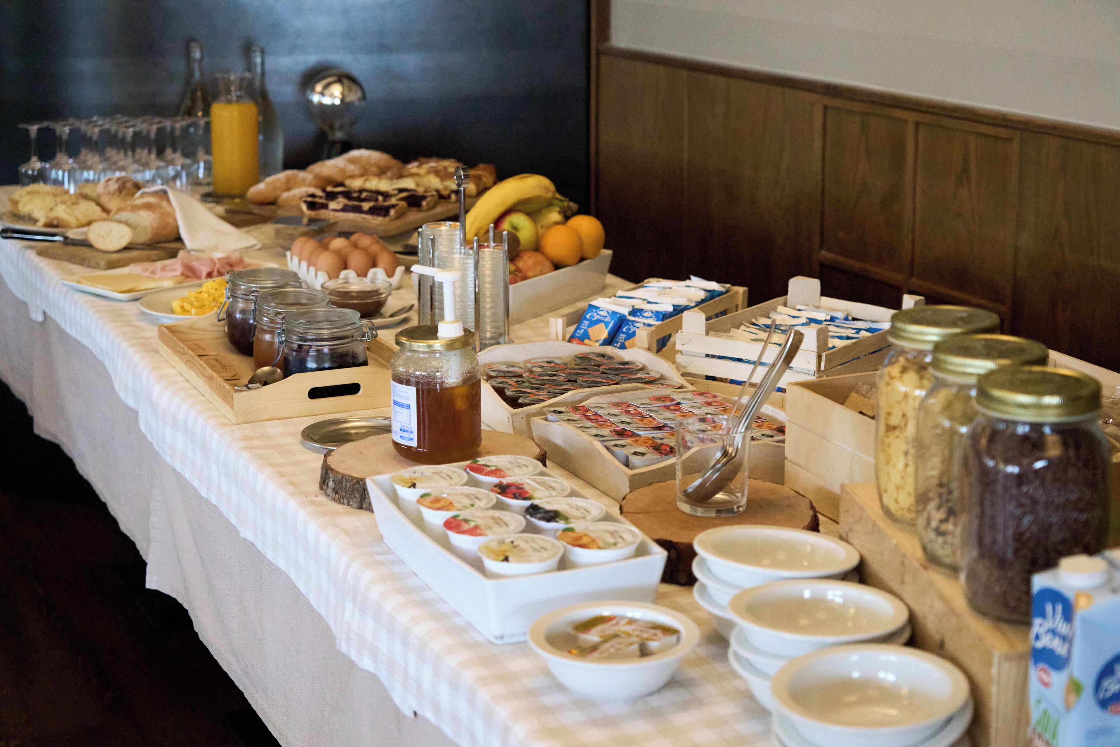 Ein Buffet mit verschiedenen Speisen, darunter Obst, Gebäck und Soßen.