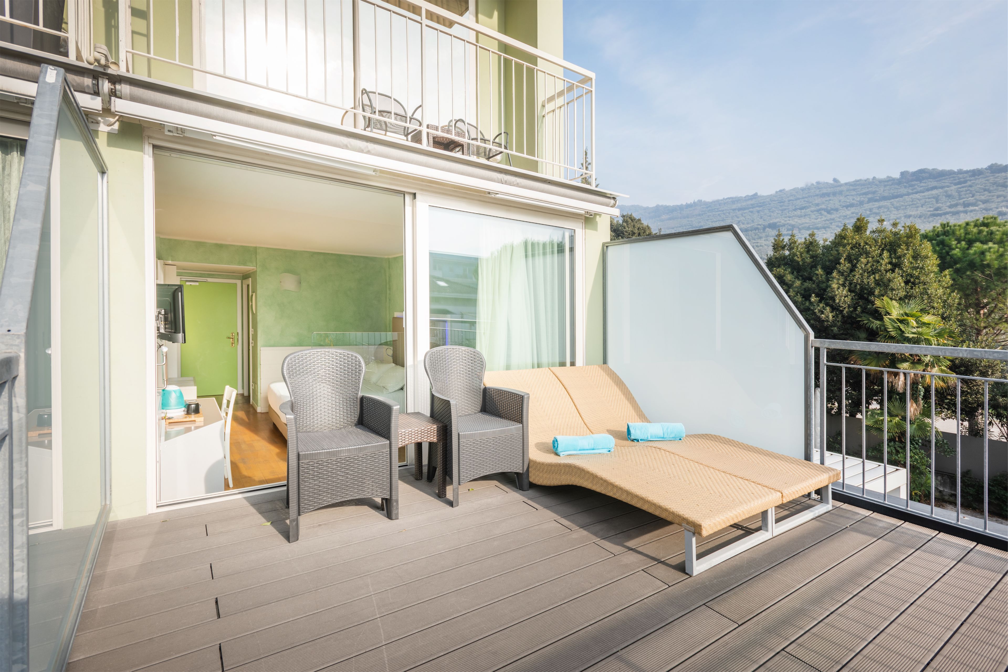 Ein Balkon mit Korbmöbeln, einer Couch und einem Tisch.