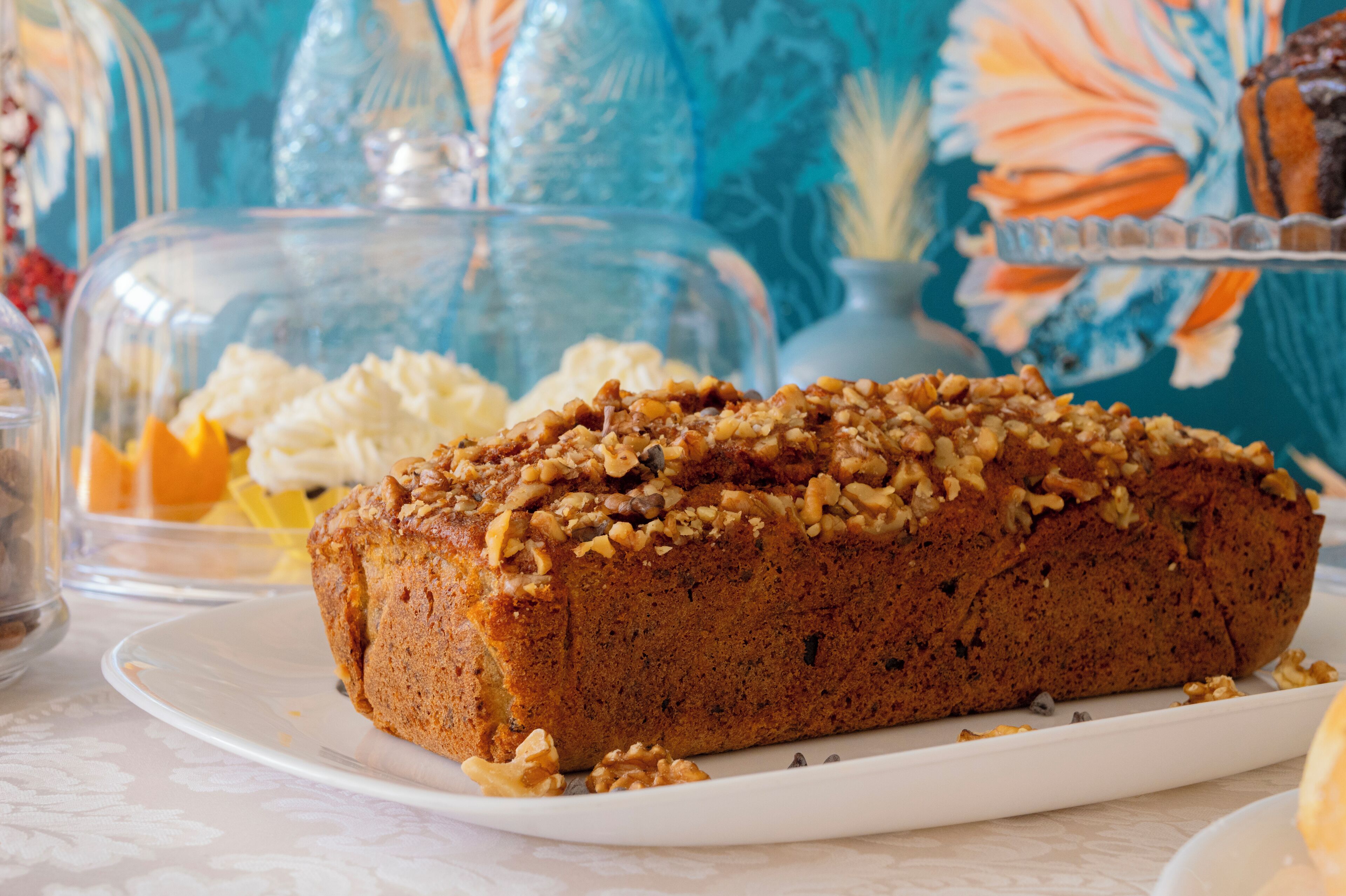 A loaf of bread with nuts on a white plate.