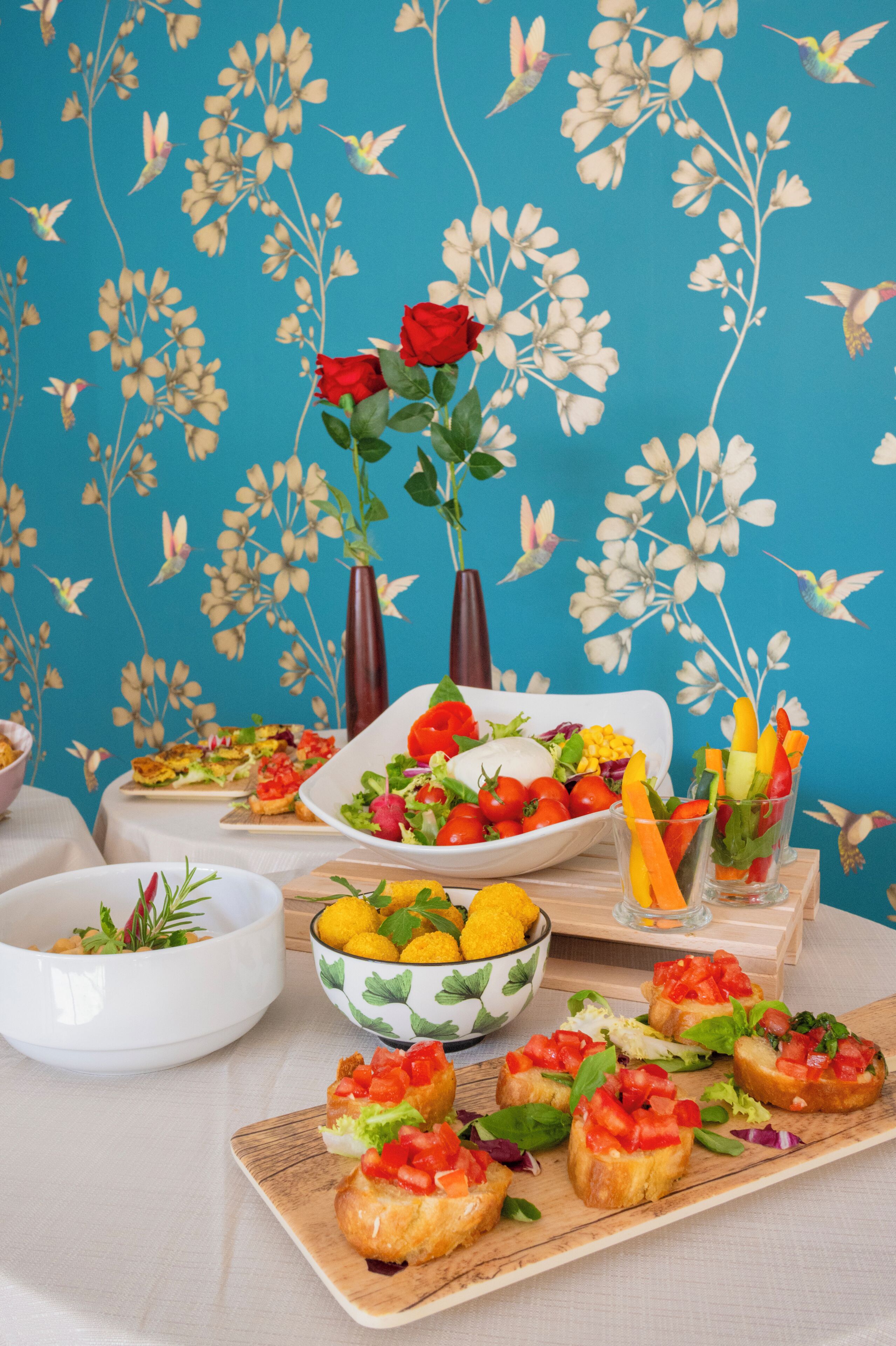 Una mesa con diferentes alimentos, entre ellos, un tazón de ensalada, un plato de bruschetta y un tazón de limones.
