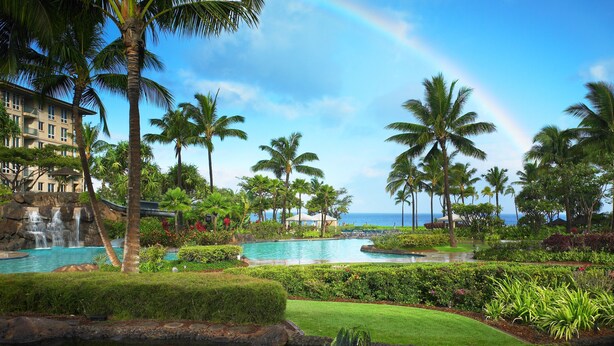 A resort with a pool, palm trees, a waterfall, and a view of the ocean. - The Westin Ka'anapali Ocean Resort Villas (Lahaina)