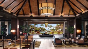 A hotel lobby with a central seating area, a large chandelier, and a view of the pool and palm trees. - The Westin Ka'anapali Ocean Resort Villas (Lahaina)