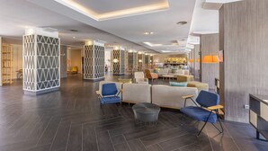 A spacious lobby with dark wooden flooring, modern seating arrangements, and a central area with a sofa and chairs. - Abora Catarina by Lopesan Hotels - All Inclusive (San Bartolomé de Tirajana)