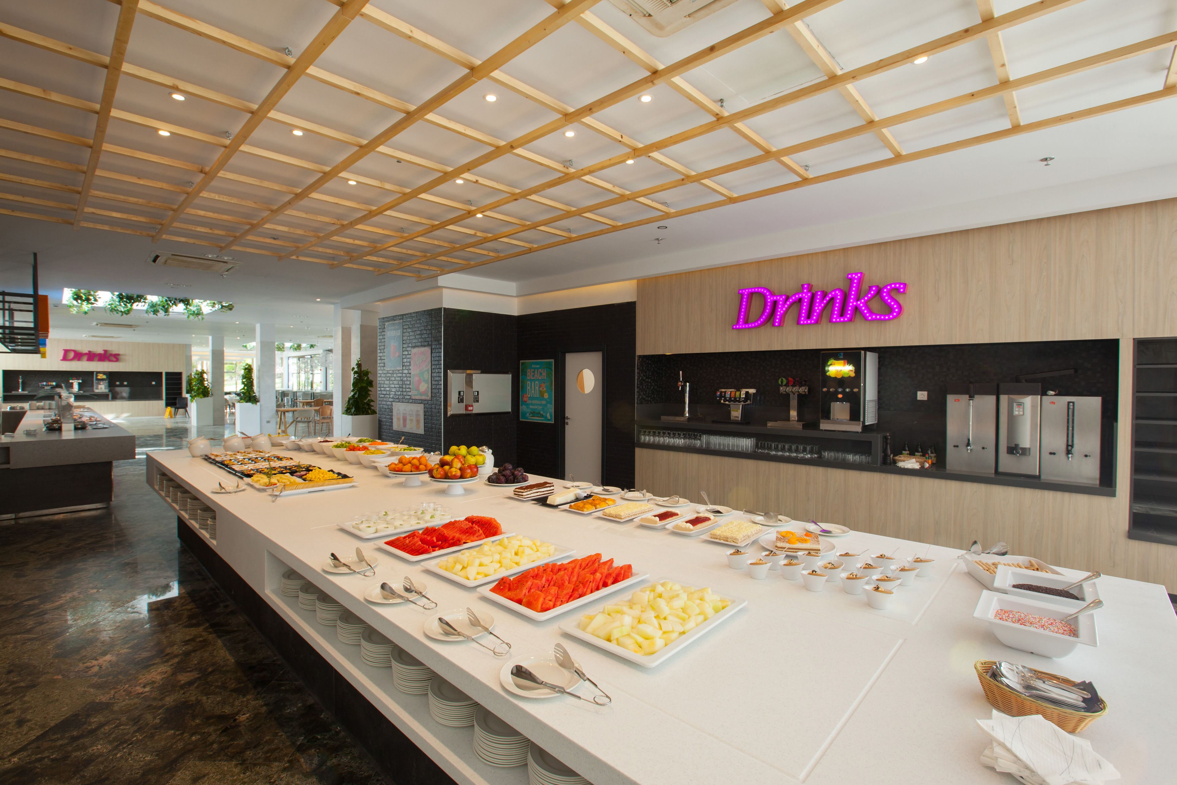 Zona de buffet con estación de bebidas y diferentes opciones de comida.