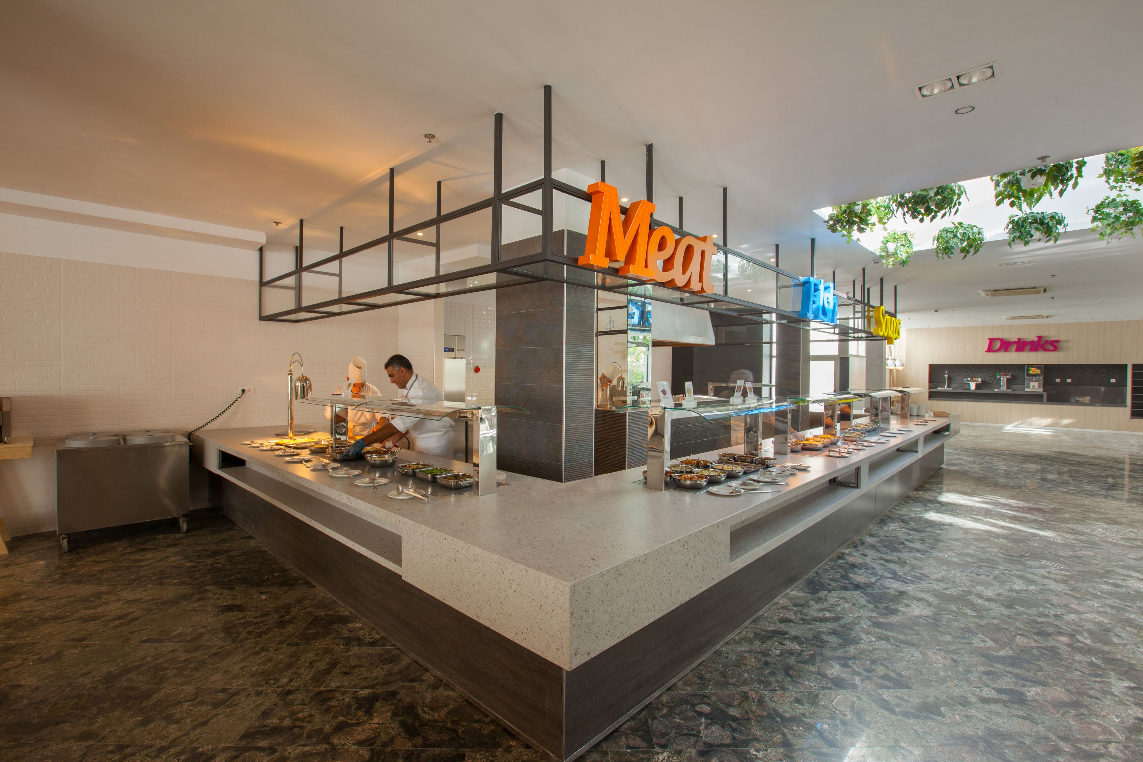 A buffet area with a 'Meat' sign, a 'Drinks' sign, and a 'Desserts' sign.