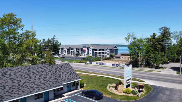 A hotel with a view of the water, a parking lot, and a road. - Traverse Bay Inn (Traverse City)