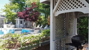 A pool area with lounge chairs and a gazebo. - Traverse Bay Inn (Traverse City)