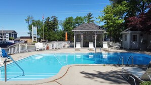 A swimming pool with lounge chairs and a gazebo. - Traverse Bay Inn (Traverse City)
