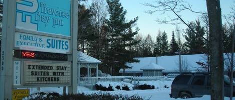 A sign for Traverse Bay Inn with family and executive suites, extended stay options, and kitchen facilities.