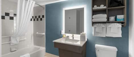Een moderne badkamer met een bad, een wastafel, een toilet en een spiegel.