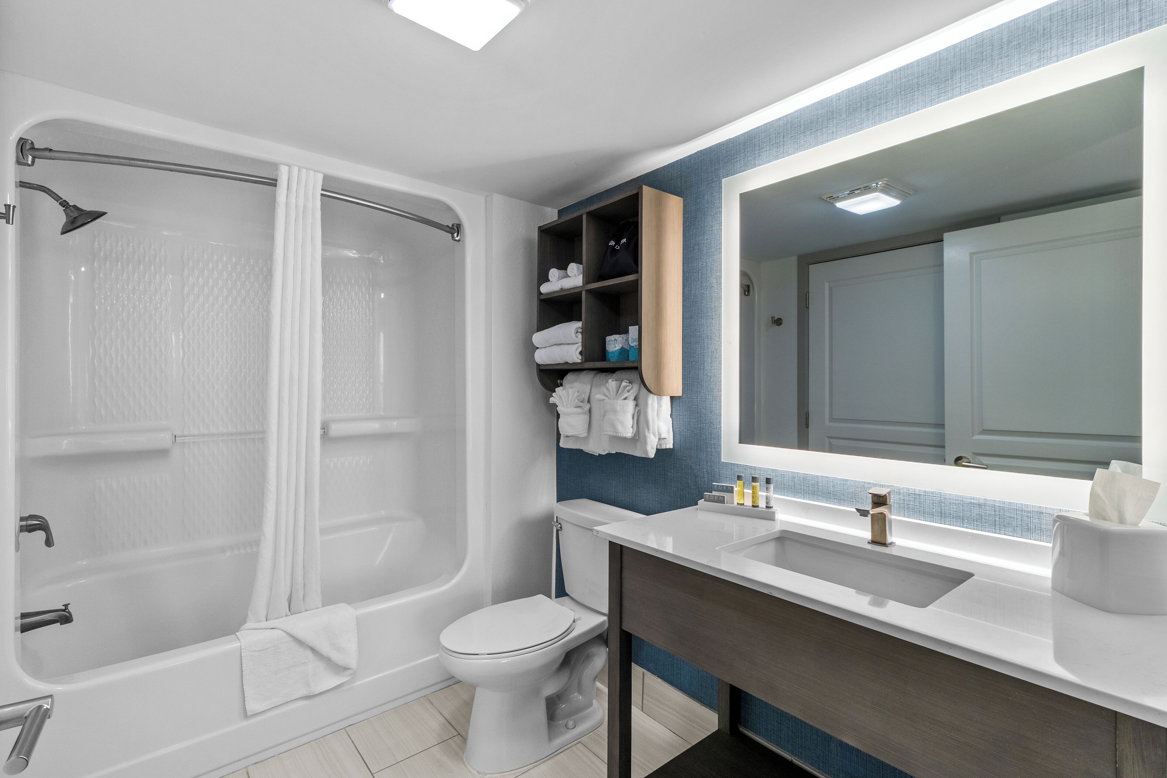 A modern bathroom with a bathtub, toilet, and vanity.
