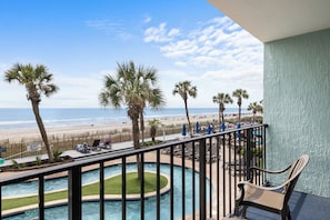 A pool area with a view of the beach and ocean. - Compass Cove Resort (Myrtle Beach)