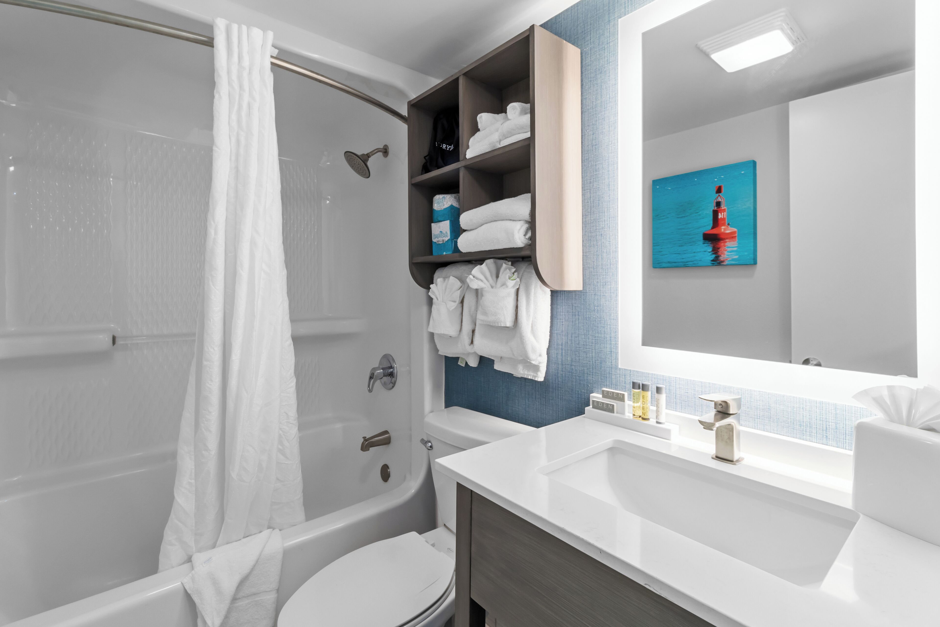 A modern bathroom with a bathtub, toilet, and a vanity with a mirror.