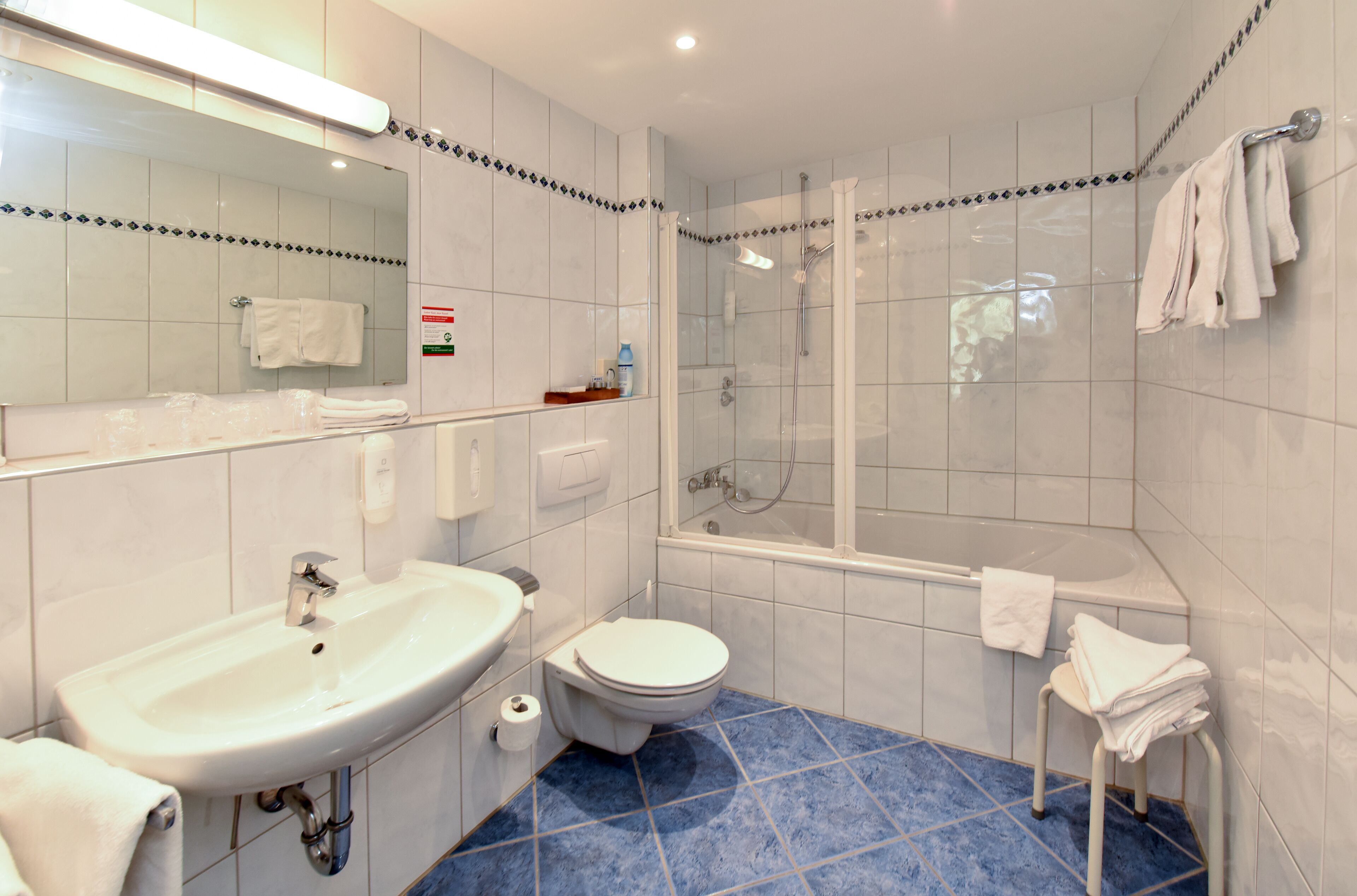 Un baño con lavamanos, inodoro y ducha.