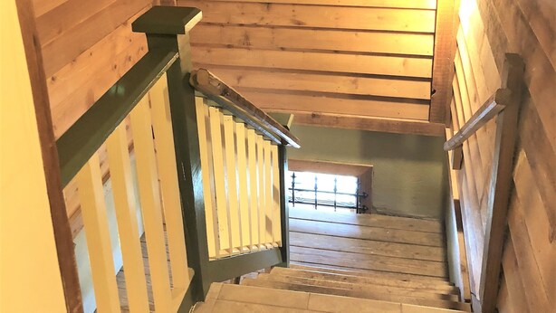 A wooden staircase with a railing, leading to a lower level. - St George Inn (St. Augustine)