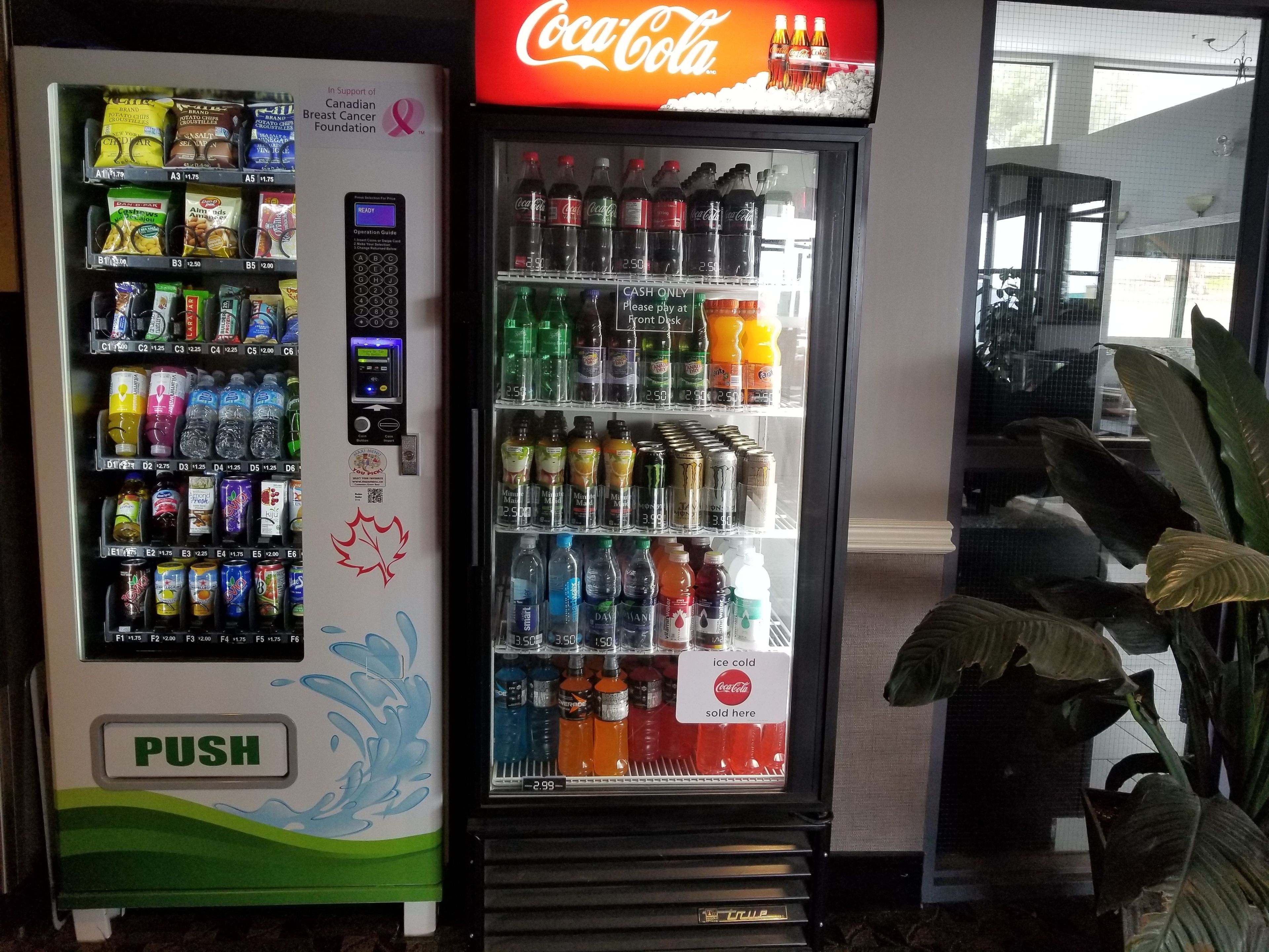 A vending machine with a Coca-Cola sign above it, selling snacks and beverages.