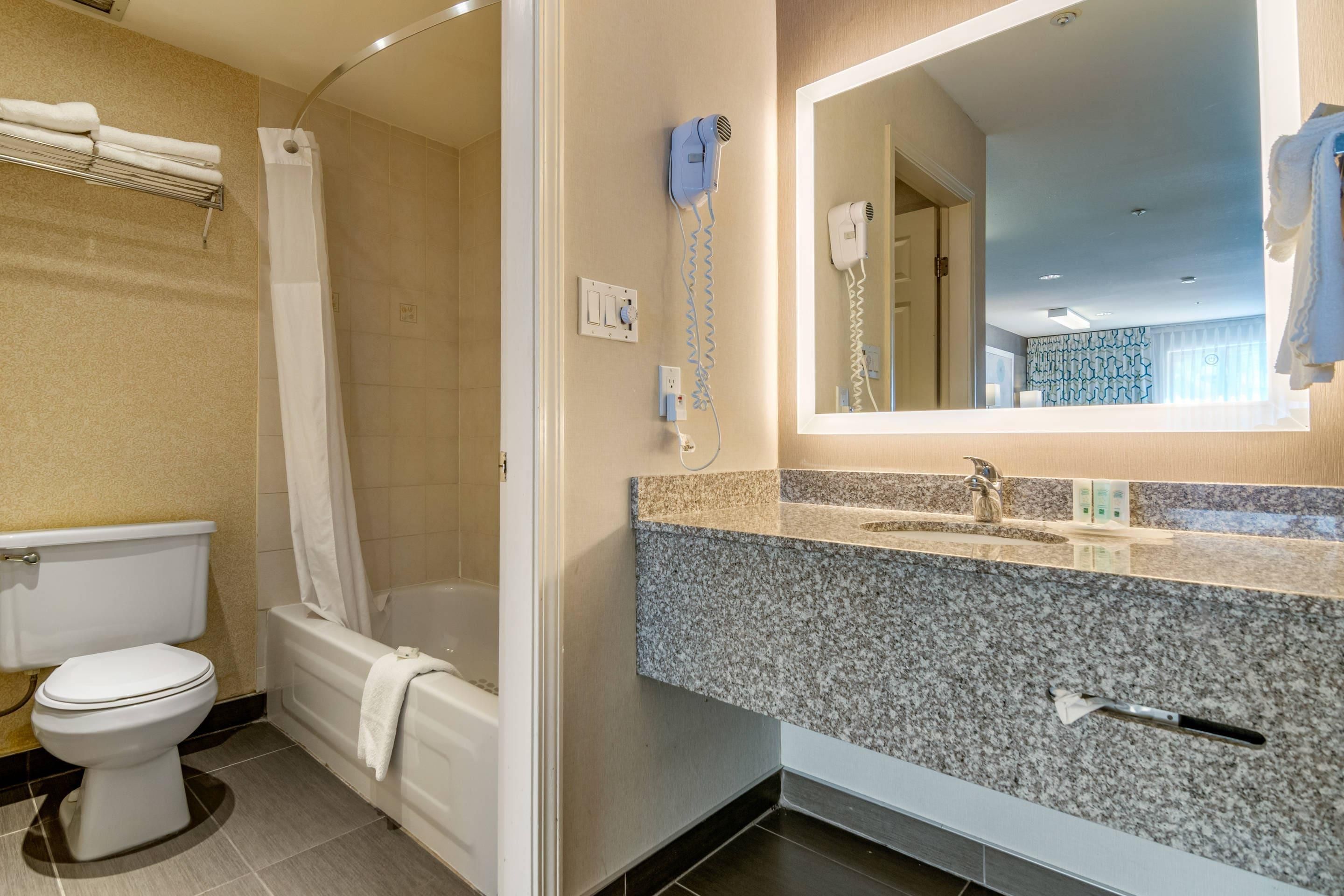 Un bagno con il water, una vasca e un lavandino con specchio.
