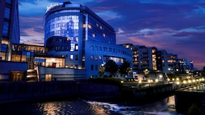A modern hotel with a curved facade, multiple floors, and a prominent sign. - Radisson Blu Hotel Nydalen, Oslo (Oslo)