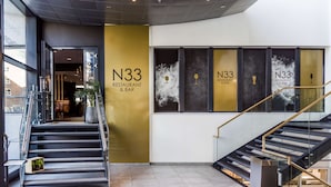 A modern interior with a staircase, a sign for N33 Restaurant & Bar, and a glass railing. - Radisson Blu Hotel Nydalen, Oslo (Oslo)