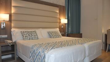Una habitación de hotel con una cama grande, dos lámparas de noche, una mesita de noche y un escritorio.