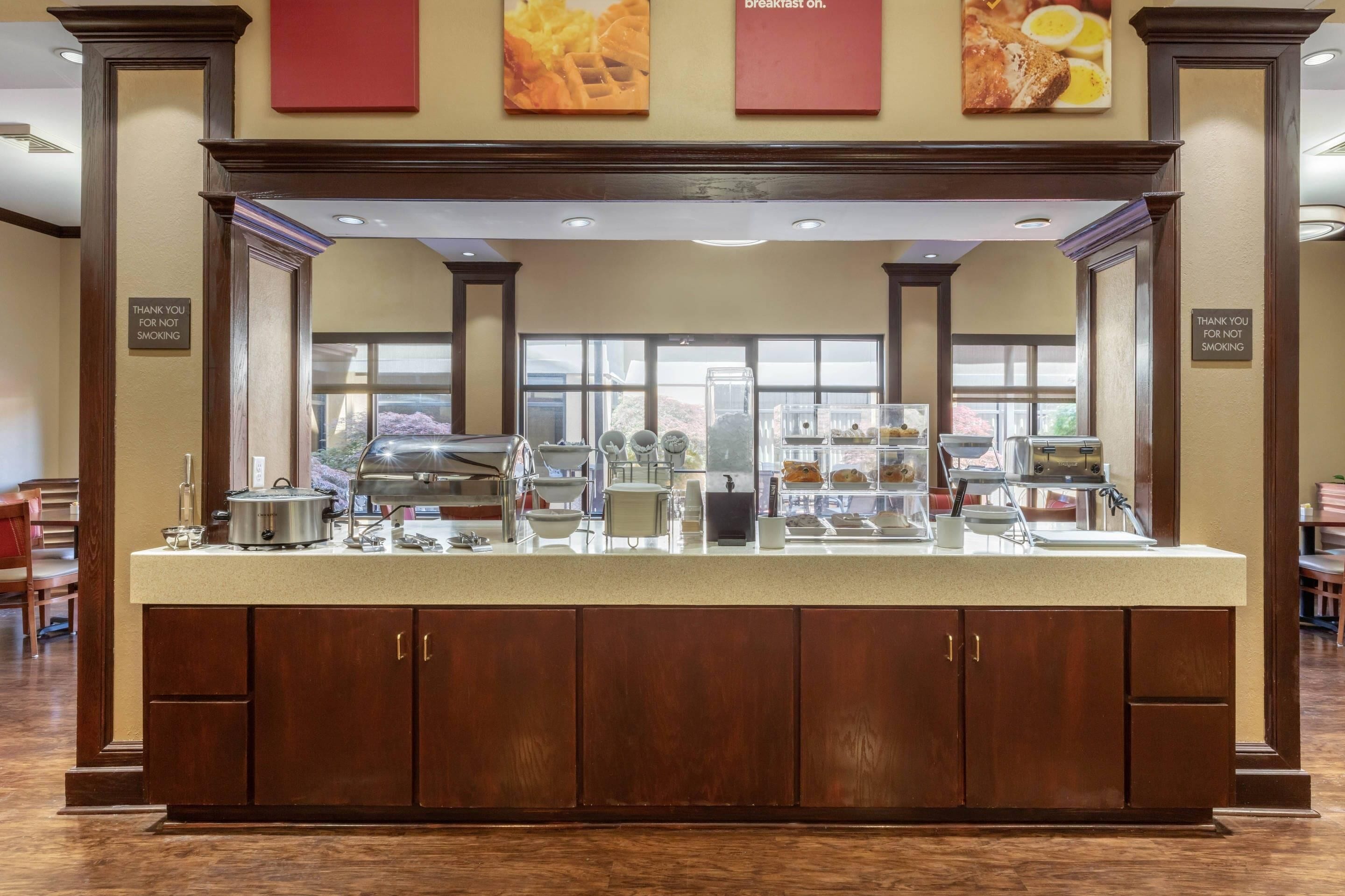 Un mostrador de buffet con una variedad de alimentos, una estación de café y una caja registradora.