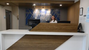 A reception desk with a wooden accent, a digital screen, and a sign for Holiday Inn Express & Suites. - Holiday Inn Express Athens by IHG (Athens)