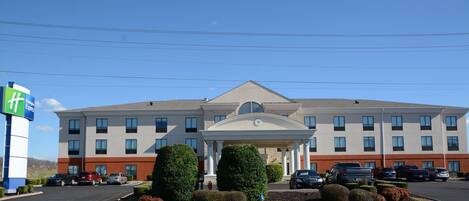 A multi-story hotel with a central entrance, parking lot, and a Holiday Inn Express sign.