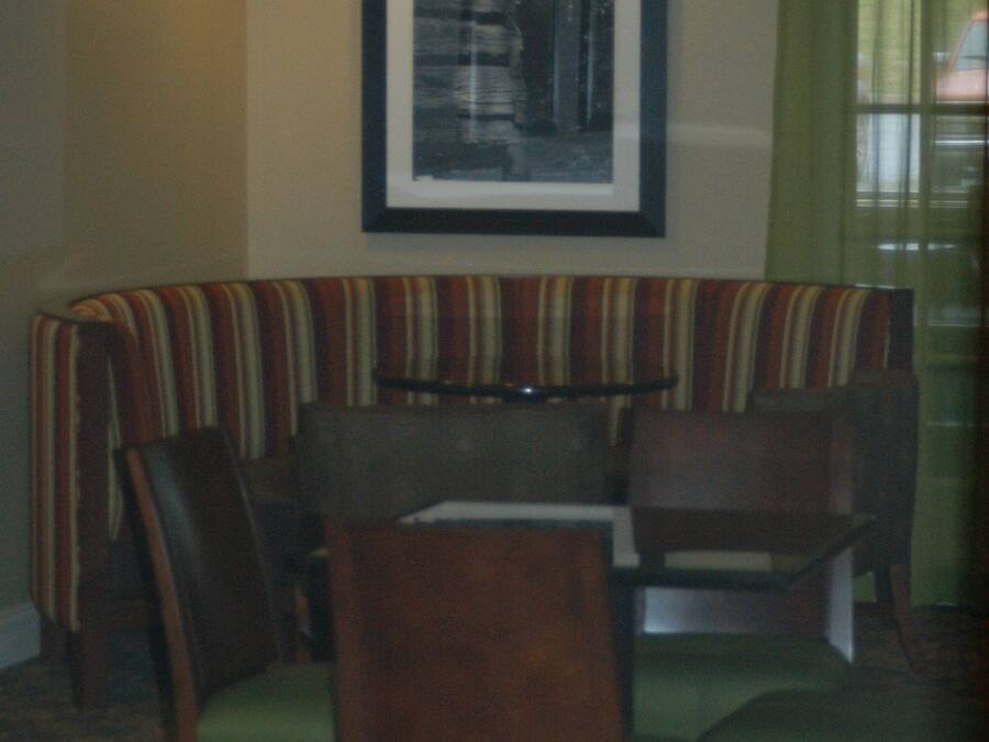 A dining area with a booth seating arrangement, a table, and chairs.