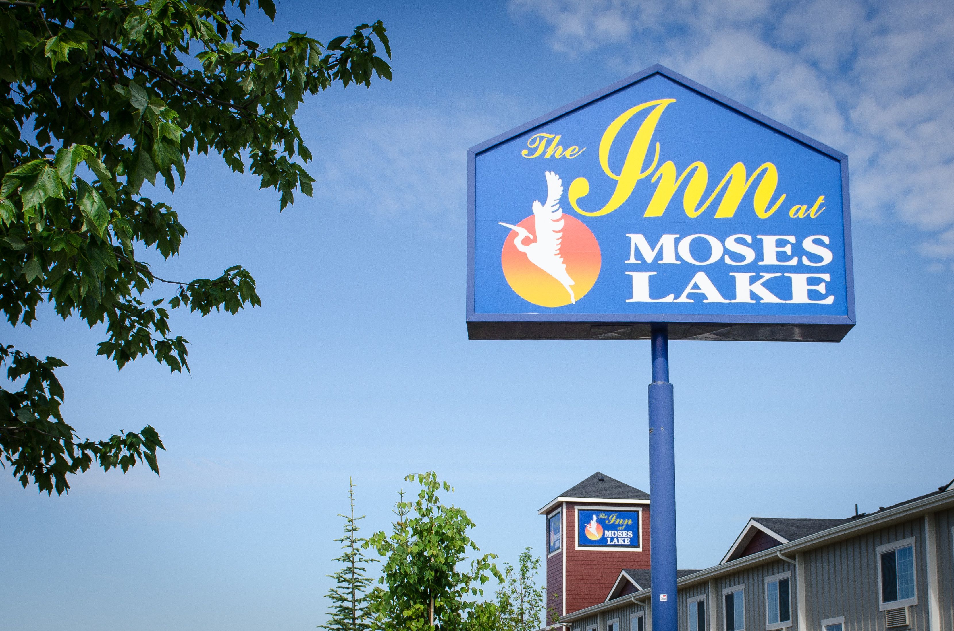 A sign for The Inn at Moses Lake with a logo of a bird and a flame.