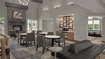 A modern interior with a fireplace, dining area, and kitchen.