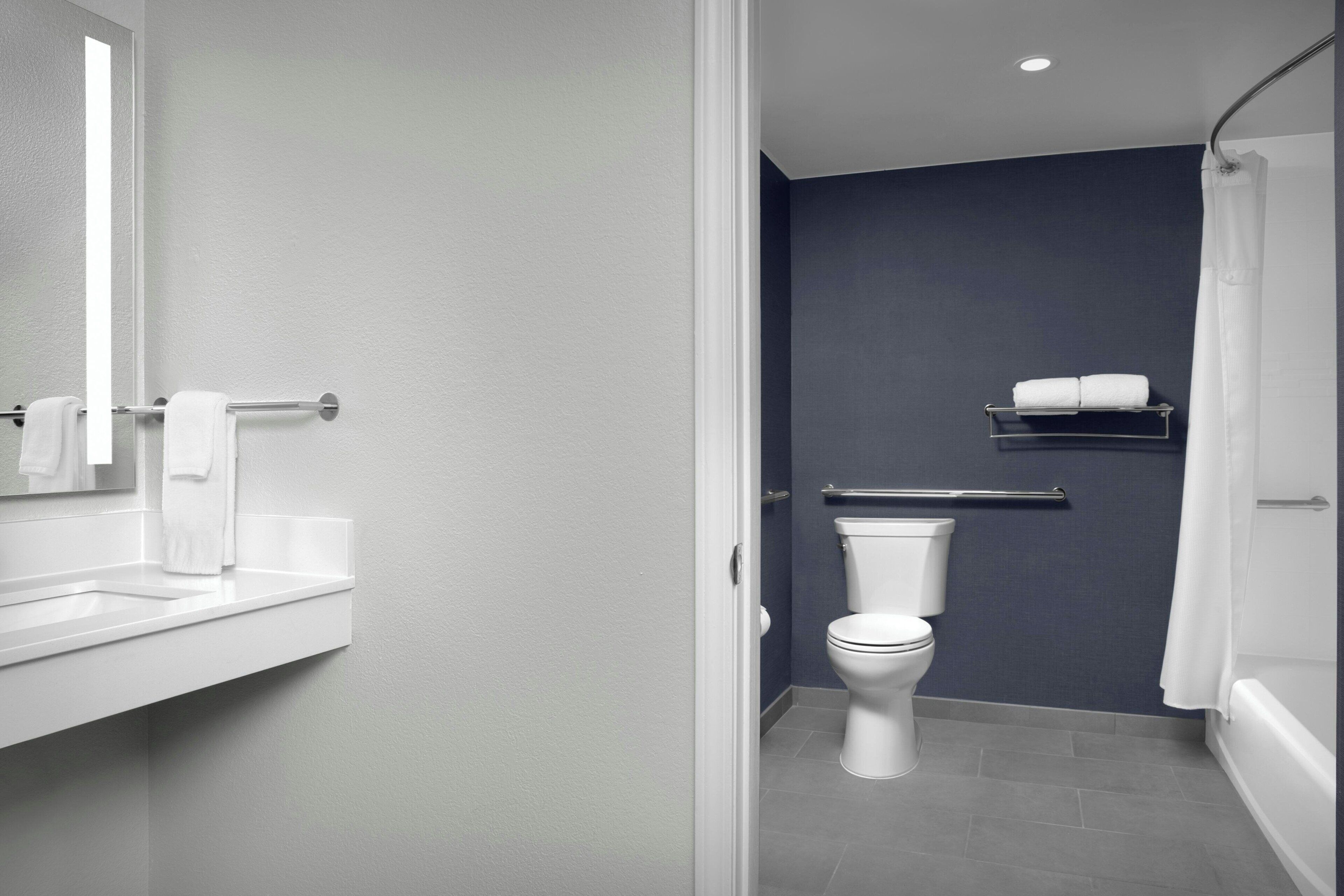 Une salle de bain moderne équipée de toilettes, d’un lavabo et d’une zone douche.
