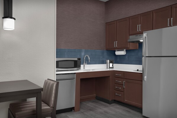 Una cocina compacta con microondas, lavabo y refrigerador.