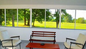 Una habitación con un banco de madera, dos sillas y una mesa.