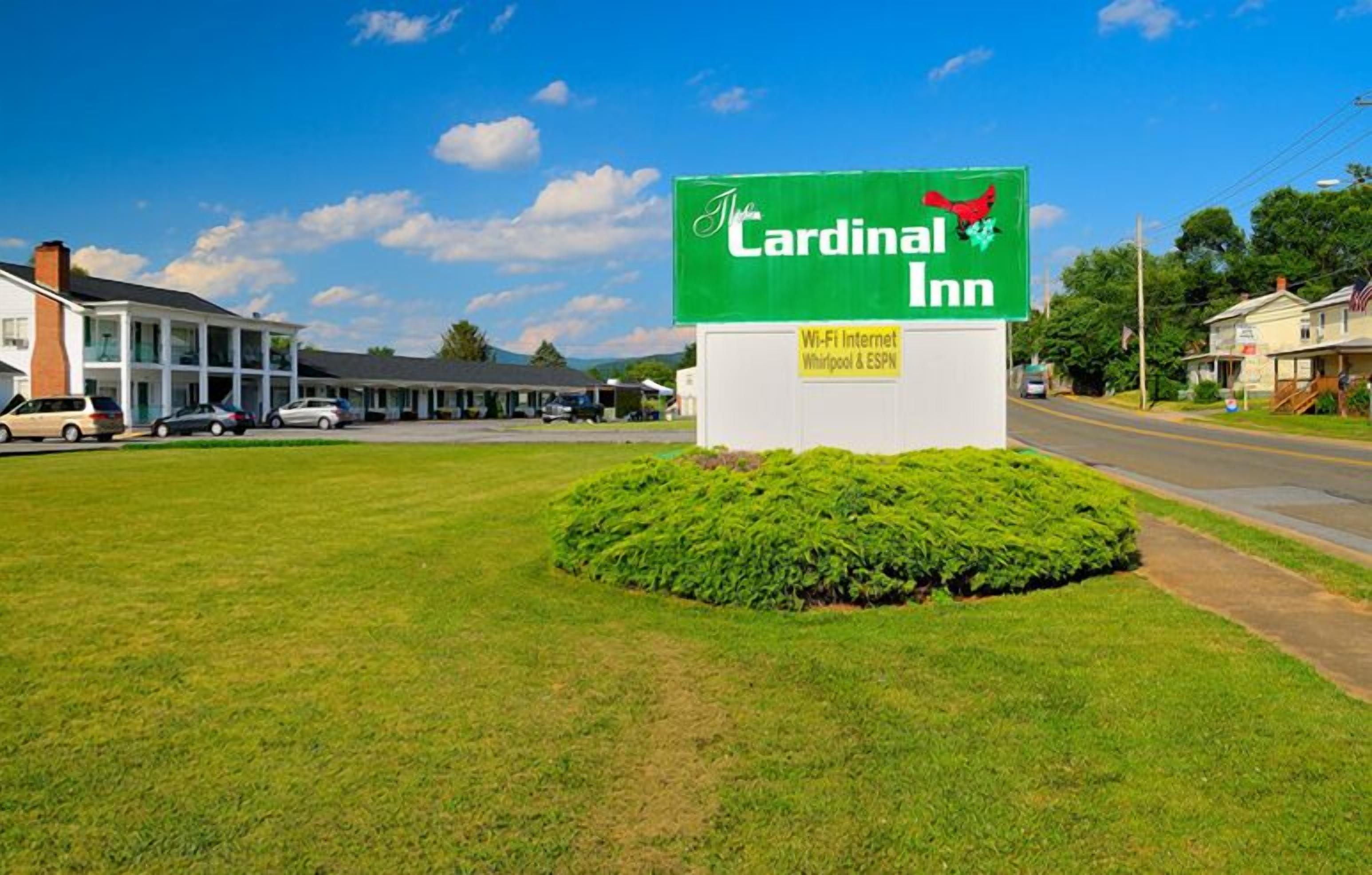 A sign for Cardinal Inn with a green background and white lettering.