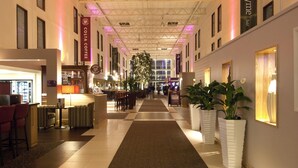En hotellobby med en receptionsdisk, en sittgrupp och en stor växt.