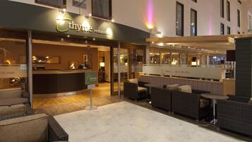 Un restaurante llamado 'thyme' con una zona de bar, asientos y un letrero que dice 'eat of ink relax'.