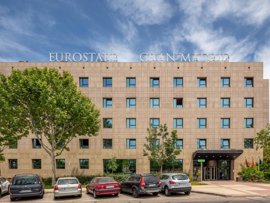 A hotel with a modern facade, multiple windows, and a clear sky.