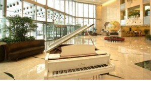 Um piano de cauda em um hall espaçoso com grandes janelas e design de interiores moderno.