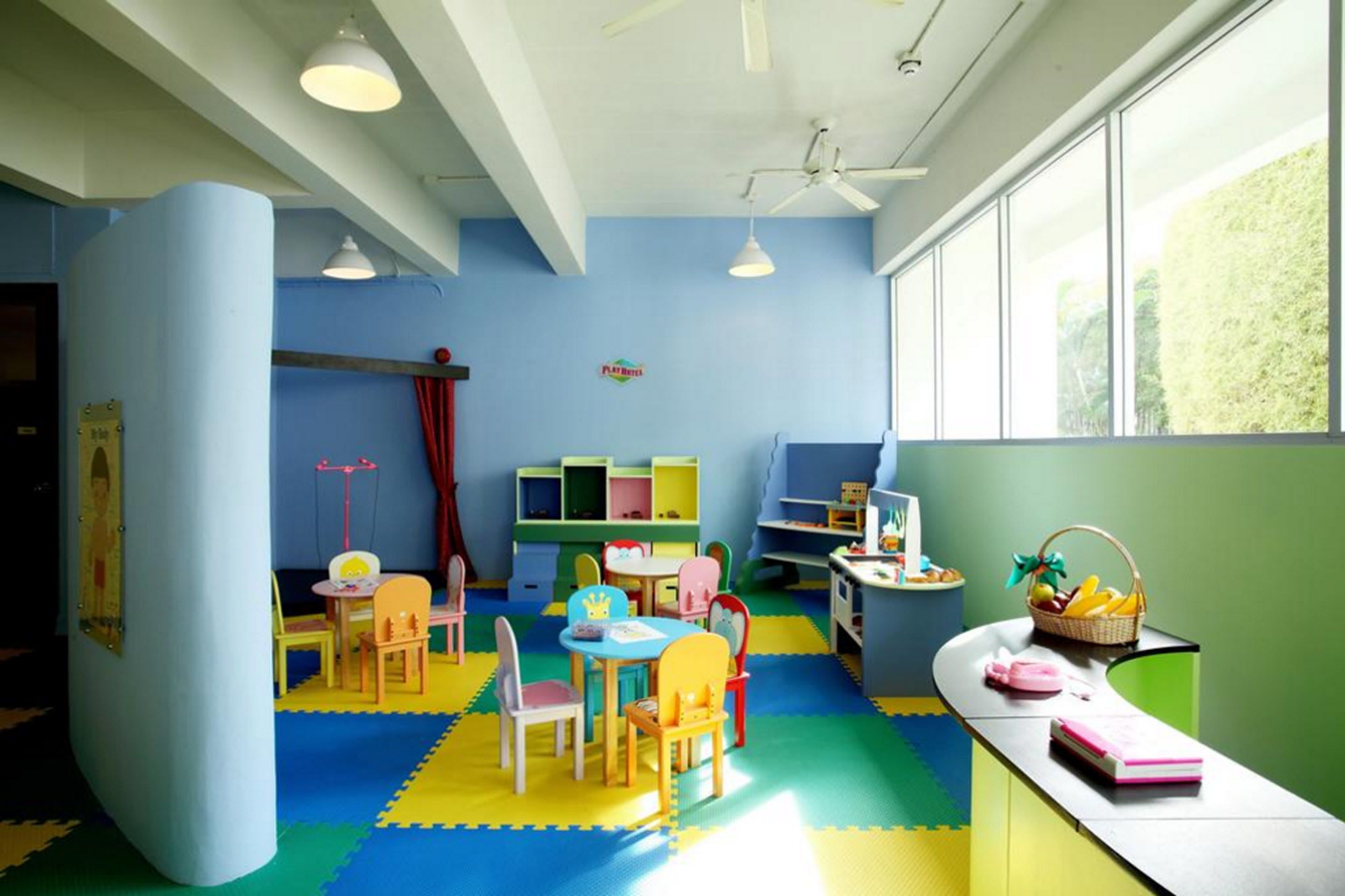 Een kleurrijke kinderspeelkamer met een groot raam, vrolijk meubilair en educatief speelgoed.